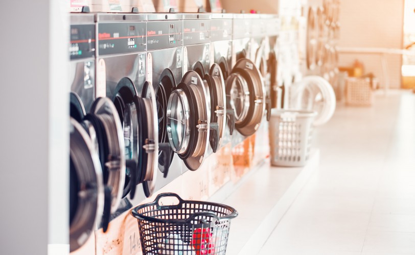 row-of-industrial-laundry-machines-in-laundromat-i-2021-08-31-06-47-21-utc-min.jpg